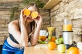 Attractive girl in sportswear is having fun, putting halves of orange to her eyes. The benefits of healthy eating