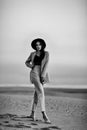 Attractive girl in suit and hat on the sunset beach