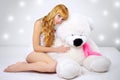 Attractive girl with a teddy bear on gray