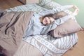 Woman waking up in the morning, lying sleepy in bed