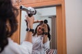 attractive girl wearing white bath robe using hair dryer Royalty Free Stock Photo
