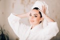 Attractive girl wearing white bathrobe and towel on head in bathroom Royalty Free Stock Photo