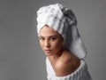 Attractive girl wearing white towel on head and white bath robe, smiling