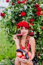 Attractive girl with a wreath of red roses with a basket of vegetables: tomatoes, eggplants, peppers Royalty Free Stock Photo