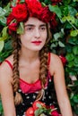 Attractive girl with a wreath of red roses with a basket of vegetables: tomatoes, eggplants, peppers Royalty Free Stock Photo