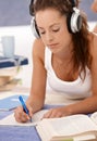 Attractive girl writing homework laying on floor Royalty Free Stock Photo