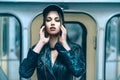 Attractive Glamorous Model Female with Close Eyes Posing Inside the Metro Train. Cute Young Woman in Leather Jacket and Royalty Free Stock Photo