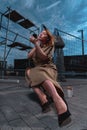 Attractive Glamorous Woman In Stylish Dress At Construction Site Doing Make Up and Sitting at Concrete Brick Royalty Free Stock Photo