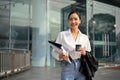 Attractive and gorgeous millennial Asian businesswoman walking along the building in the city Royalty Free Stock Photo