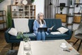 Attractive grey-haired woman presenting financial report to colleagues through video call on laptop Royalty Free Stock Photo