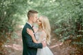 Attractive groom in green suit kisses tender bride`s cheek Royalty Free Stock Photo