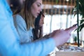 Attractive guy and girl having a great time together at a coffee shop while using their mobile phones Royalty Free Stock Photo