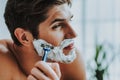 Attractive guy shaving his beard by razor Royalty Free Stock Photo