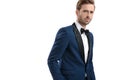 Attractive guy in tuxedo standing with hand in pocket