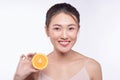 Attractive half-naked asian woman amiling while holding orange slices near her face Royalty Free Stock Photo