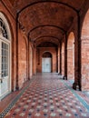 a hallway with colorful tiles, arched ceiling and columns and windows