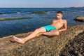 Attractive handsome naked young man on rock near the sea wa Royalty Free Stock Photo