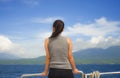 Attractive and happy Asian Chinese woman on excursion ship or ferry looking ocean and island enjoying sea breeze on summer holiday