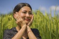 Attractive and happy Asian Chinese woman 40s or 50s enjoying nature excited and carefree playful at tropical rice field during
