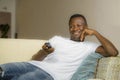 Attractive and happy black afro American man relaxed at home sofa couch enjoying watching television sports or movie smiling Royalty Free Stock Photo