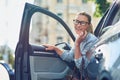 Attractive happy business woman in classic wear getting out of her modern car, talking on mobile phone and smiling Royalty Free Stock Photo