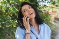 Attractive happy cheerful young Caucasian woman with charming smile wearing blue shirt talking on mobile phone about the planinng Royalty Free Stock Photo