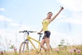 Attractive female cyclist with yellow mountain bicycle, enjoying sunny day in the mountains Royalty Free Stock Photo