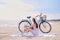 Portrait of beautiful brunette with her bike at the seaside