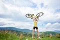 Attractive female cyclist with yellow mountain bicycle, enjoying sunny day in the mountains Royalty Free Stock Photo