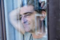 Attractive and happy grey hair man on his 40s or 50s looking throw window glass leaning tranquil and satisfied looking thoughtful Royalty Free Stock Photo