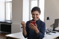 Indian woman employee read great news on smartphone feels overjoyed