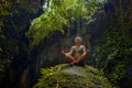 Attractive and happy mid adult woman with grey hair 40s or 50s enjoying blissful and free sitting in lotus yoga pose at beautiful Royalty Free Stock Photo