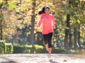 Attractive and happy runner woman in Autumn sportswear running a Royalty Free Stock Photo