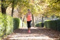 Attractive and happy runner woman in Autumn sportswear running a Royalty Free Stock Photo