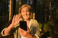 Attractive happy senior elderly woman having video chat outdoors, waving. Conversation on cellphone smartphone webcam Royalty Free Stock Photo