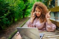 Attractive happy stylish plus size African American Black business woman speaks phone working online on laptop computer Royalty Free Stock Photo