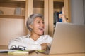 Attractive and happy successful middle aged business Asian woman working at laptop computer desk smiling confident in entrepreneur Royalty Free Stock Photo