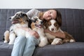 Attractive happy woman hug three merle colours Australian shepherd puppy dog Royalty Free Stock Photo