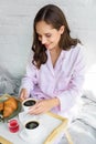 attractive happy woman in pink pajamas having breakfast on tray Royalty Free Stock Photo