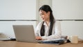 An attractive Asian businesswoman is working on her laptop at her desk in a modern office Royalty Free Stock Photo