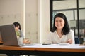 Attractive and happy young Asian businesswoman at her office desk Royalty Free Stock Photo