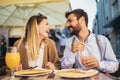 Happy young couple having good time in cafe restaurant. They are smiling and eating a pizza Royalty Free Stock Photo