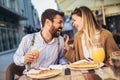 Happy young couple having good time in cafe restaurant. They are smiling and eating a pizza Royalty Free Stock Photo