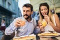 Happy young couple having good time in cafe restaurant. They are smiling and eating a pizza Royalty Free Stock Photo