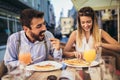 Young couple having good time in cafe restaurant. They are smiling and eating a pizza Royalty Free Stock Photo