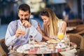 Happy young couple having good time in cafe restaurant. They are smiling and eating a pizza Royalty Free Stock Photo