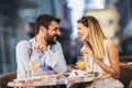 Happy young couple having good time in cafe restaurant. They are smiling and eating a pizza Royalty Free Stock Photo