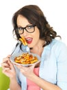 Attractive Happy Young Hispanic Woman Eating a Plate of Tomato and Basil Penne Pasta Royalty Free Stock Photo