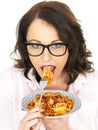 Attractive Happy Young Hispanic Woman Eating a Plate of Tomato and Basil Penne Pasta Royalty Free Stock Photo