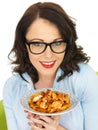 Attractive Happy Young Hispanic Woman Holding a Plate of Fusilli Tomato and Basil Pasta Royalty Free Stock Photo